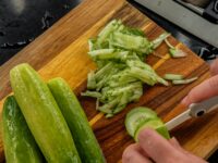 cucumbers being chopped on cutting board